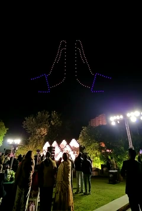 Folded hands formed in drone light above the fort